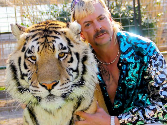 This undated photo courtesy of Netflix shows Joseph "Joe Exotic" Maldonado-Passage with one of his tigers. - Amid a constant swirl of grim coronavirus news, the surreal tale of a gay, mullet-wearing private zookeeper who calls himself "Joe Exotic" --  now in prison for murder-for-hire -- has captivated a nation stuck on the couch.  "Tiger King: Murder, Mayhem and Madness" -- featuring a menagerie of big cats, wacky employees and misfit lovers -- is part "Animal Planet" and part "Breaking Bad." And it's all true. (Photo by - / Netflix US / AFP) / RESTRICTED TO EDITORIAL USE - MANDATORY CREDIT "AFP PHOTO / NETFLIX" - NO MARKETING - NO ADVERTISING CAMPAIGNS - DISTRIBUTED AS A SERVICE TO CLIENTS / TO  GO WITH AFP STORY by Paul HANDLEY, "'Tiger King': true-crime tale of 'Joe Exotic' grips shut-in nation"