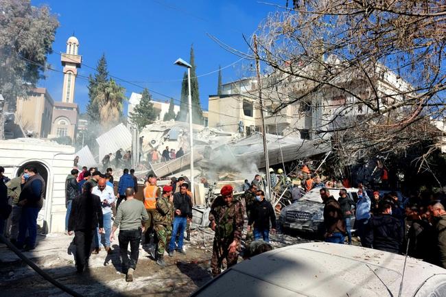 People and security forces gather in front of a building destroyed in a reported Israeli strike in Damascus on January 20