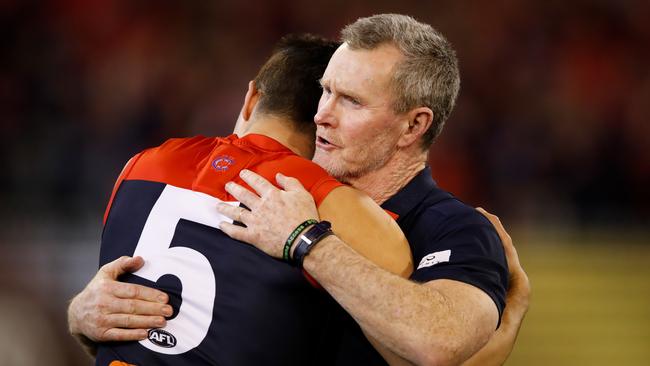 Brendan McCartney embraces Christian Petracca after a Melbourne win. Picture: Adam Trafford/AFL Media/Getty Images.