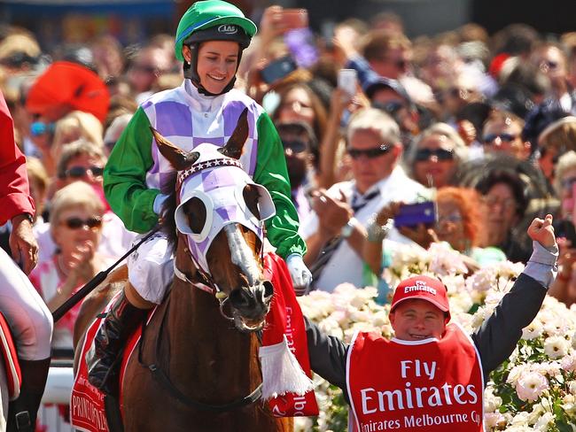 Michelle Payne is escorted by her jubilant brother Steven Payne.