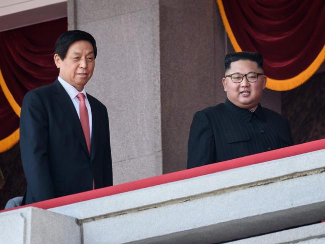 North Korea's leader Kim Jong Un (C) walks with China's Chairman of the Standing Committee of the National People's Congress Li Zhanshu (L) on a balcony of the Grand People's House on Kim Il Sung square following a military parade and mass rally in Pyongyang on September 9, 2018. - Thousands of North Korean troops followed by artillery and tanks paraded through Pyongyang on September 9 as the nuclear-armed country celebrated its 70th birthday, but it refrained from displaying the intercontinental ballistic missiles that have seen it hit with sanctions. (Photo by Ed JONES / AFP)