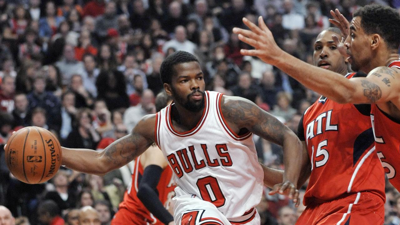 Chicago Bulls' Aaron Brooks (0) passes around Atlanta Hawks' Al Horford (15) and Thabo Sefolosha (25) during the second half of an NBA basketball game in Chicago, Saturday, Jan. 17, 2015. Atlanta won 107-99. (AP Photo/Paul Beaty)