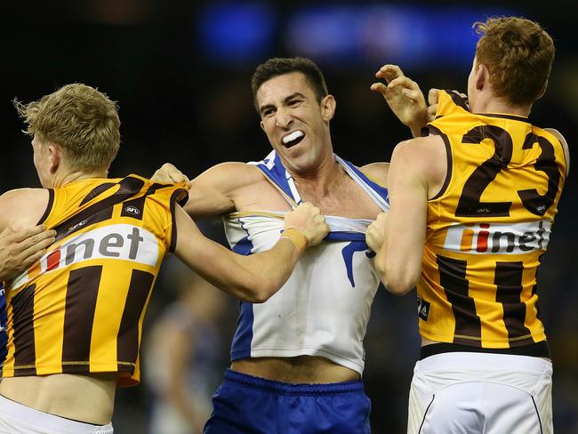 North Melbourne defender Michael Firrito wrestles with Hawthorn pair James Sicily and Tim O'Brien last Friday night. Picture: Wayne Ludbey