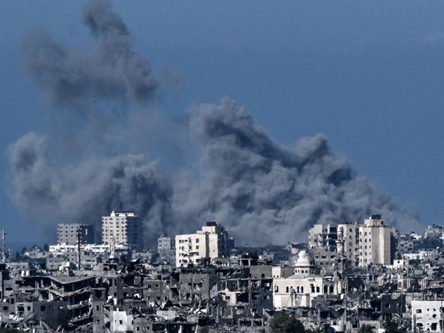 A picture taken from the Israeli side of the border with the Gaza Strip shows smoke rising behind destroyed buildings in the Palestinian enclave. Picture: AFP