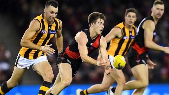 MELBOURNE, AUSTRALIA – JUNE 14: Zach Merrett of the Bombers handballs during the round 13 AFL match between the Essendon Bombers and the Hawthorn Hawks at Marvel Stadium on June 14, 2019 in Melbourne, Australia. (Photo by Quinn Rooney/Getty Images)