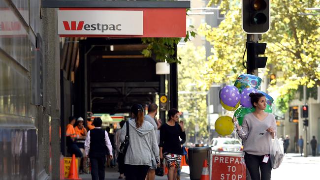 People walk past a Westpac Bank sign in Sydney. (AFP PHOTO/WILLIAM WEST)