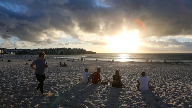 Beachgoers enjoying the sunrise on New Years Day at Bondi. Picture: Newscorp Daily Telegraph / Gaye Gerard