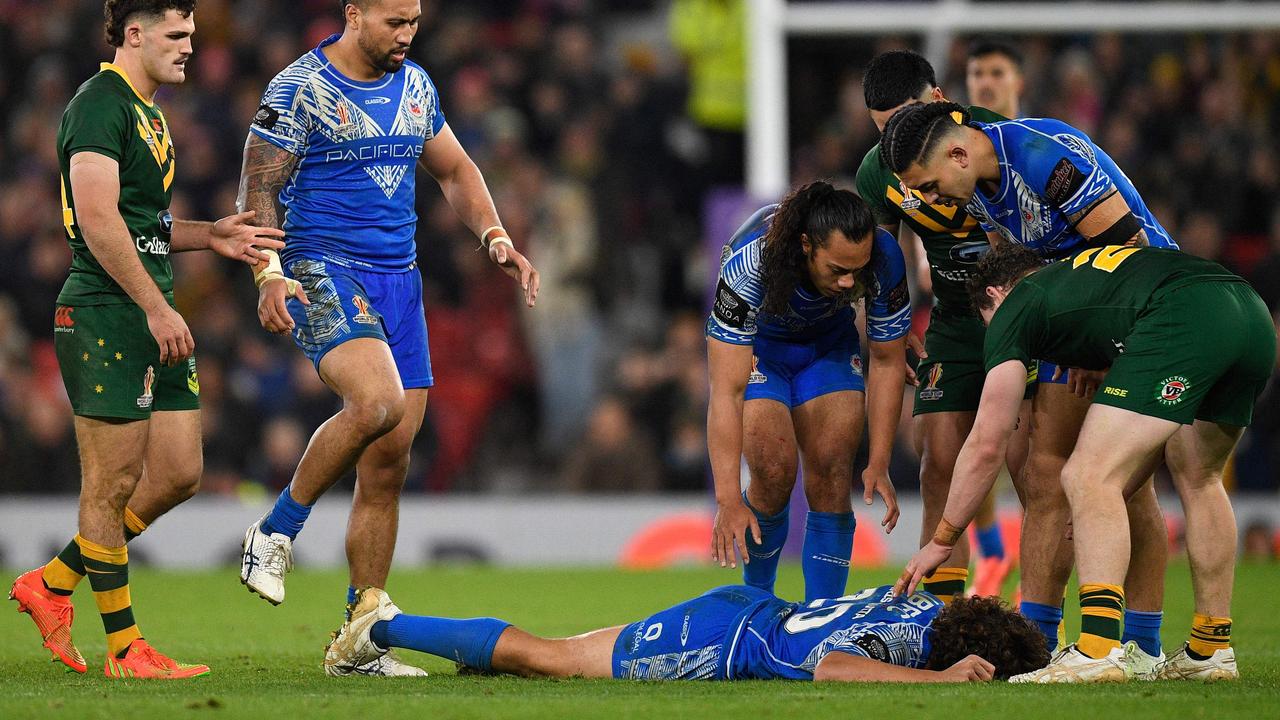 Players check on Samoa's Chanel Harris-Tavita during the Rugby League World Cup Men's final between Australia and Samoa. (Photo by Oli SCARFF / AFP)