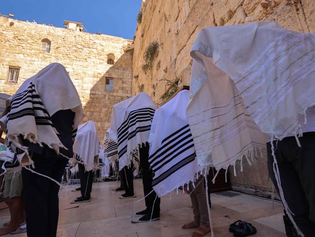 Jewish men wearing protective face masks and traditional Jewish prayer shawls pray at the Western Wall in the old city of Jerusalem. Picture: AFP