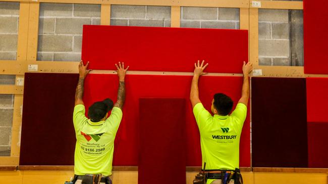 Apprentice carpenter Cameron Weidel and site forman Nathan Bolger install wall panels at the theatre.