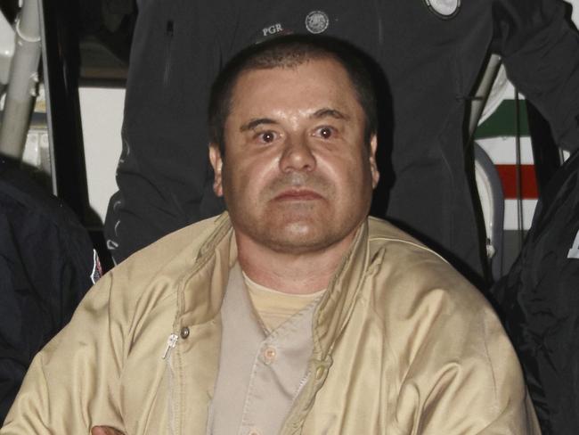 In this Jan. 19, 2017 photo provided by the United States Drug Enforcement Administration, authorities escort Joaquin "El Chapo" Guzman, center, from a plane to a waiting caravan of SUVs at Long Island MacArthur Airport in Ronkonkoma, N.Y. The notorious Mexican drug lord was convicted of drug-trafficking charges, Tuesday, Feb. 12 2019, in federal court in New York. (United States Drug Enforcement Administration via AP, File)