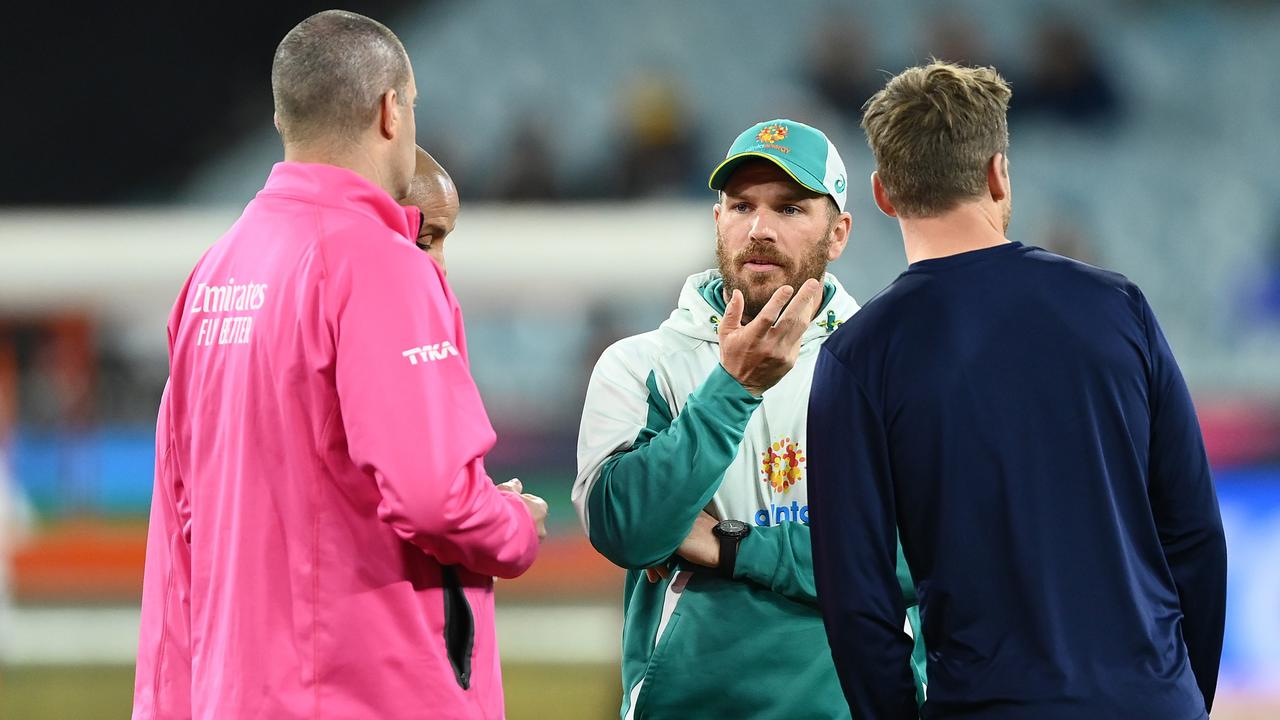 MELBOURNE, AUSTRALIA - OCTOBER 28: Jos Buttler of England and Aaron Finch of Australia speak with the umpires as rain delays play during the ICC Men's T20 World Cup match between England and Australia at Melbourne Cricket Ground on October 28, 2022 in Melbourne, Australia. (Photo by Quinn Rooney/Getty Images)