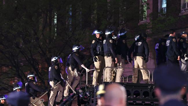 NYPD officers in riot gear wait to break into a building at Columbia University. Picture: AFP.