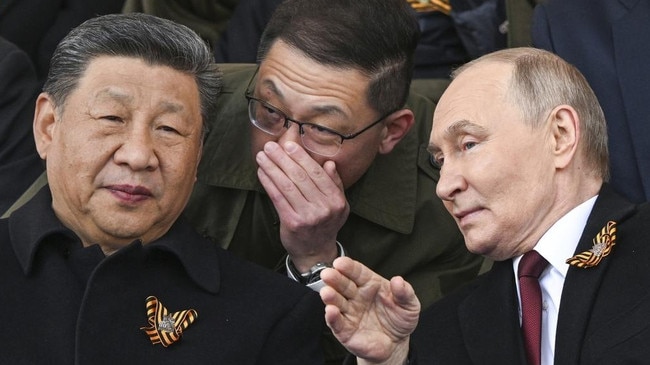 Vladimir Putin and Xi Jinping talk as they watch the Victory Day military parade in Moscow in May.