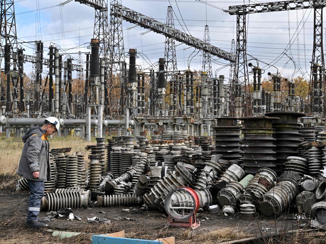 (FILES) In this file photo taken on October 27, 2022, a worker examines damage as he repairs  power line equipment destroyed after a missile strike on a power plant, in an undisclosed location of Ukraine, amid the Russian invasion of Ukraine. - Russian drones and missile strikes led to power cuts in 