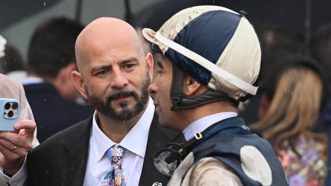 MELBOURNE, AUSTRALIA - OCTOBER 05:  Joao Moreira talks to Ozzie Kheir and other connections after riding Buckaroo to finish second in Race 8, theTab Turnbull Stakes - Betting Odds during Melbourne Racing at Flemington Racecourse on October 05, 2024 in Melbourne, Australia. (Photo by Vince Caligiuri/Getty Images)