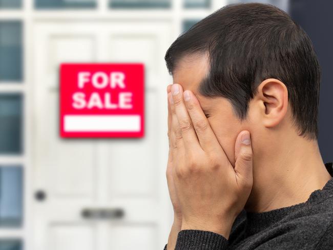 Man extremely depressed and sad about losing his house key and seeing a for sale sign, real estate concept; first home buyer generic sad, stressed