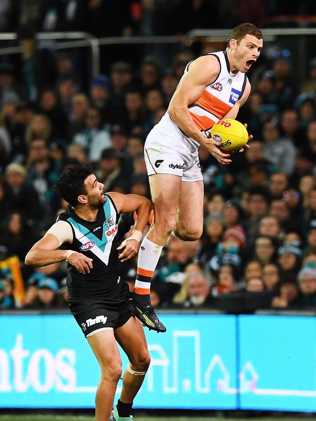 Heath Shaw of the Giants takes a huge leaping mark over Lindsay Thomas on Sunday. Picture: Mark Brake/Getty Images