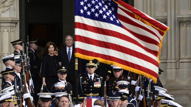 George W. Bush and Laura Bush, centre, follow the casket as it is carried out of the National Cathedral in Washington. Picture: AP.