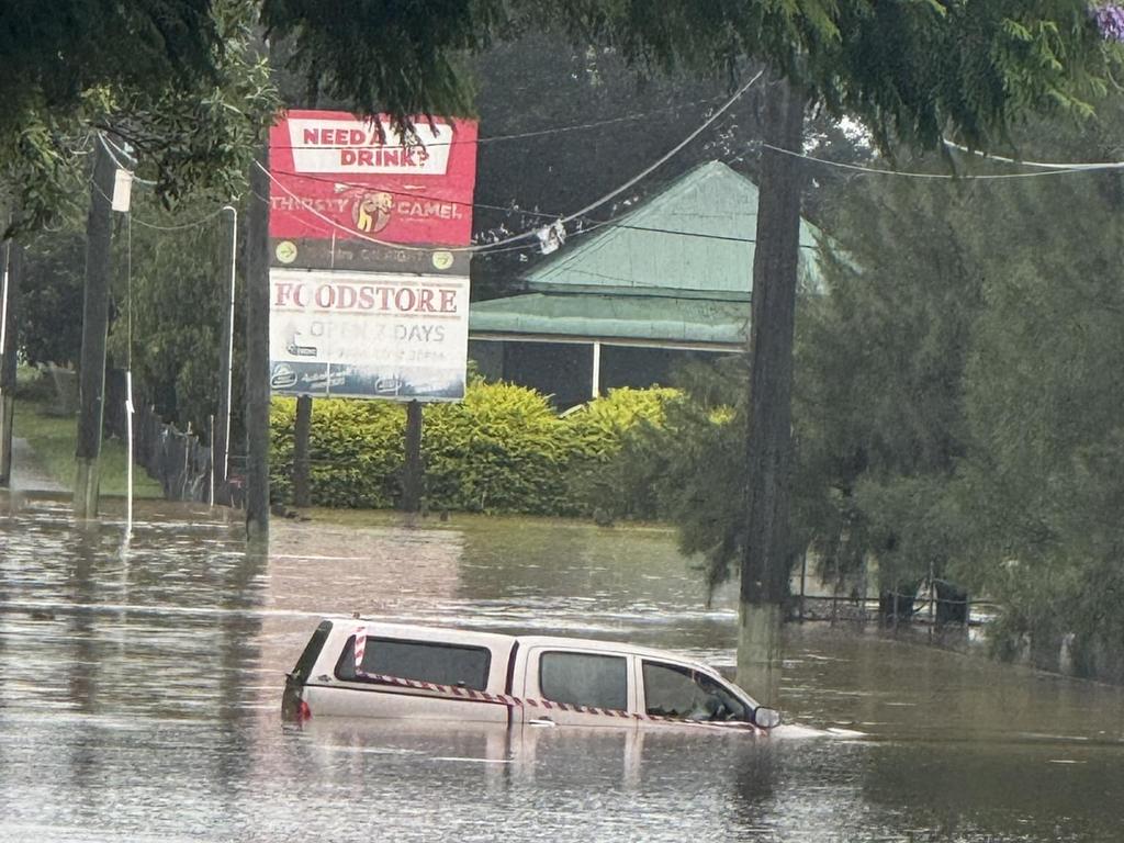 A car goes under floodwater from Cyclone Alfred at South Station Road in Booval, Ipswich. Picture: Molly Arlott/ Facebook