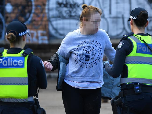 Victoria Police officers search a woman during a patrol near Victoria Street in Melbourne in May. Picture: James Ross