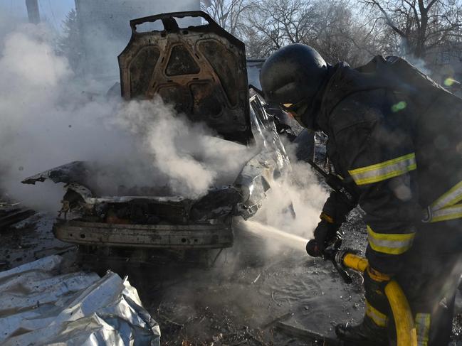 A firefighter extinguishes a burning car at a site of a Russian strike in Kharkiv. Picture: AFP