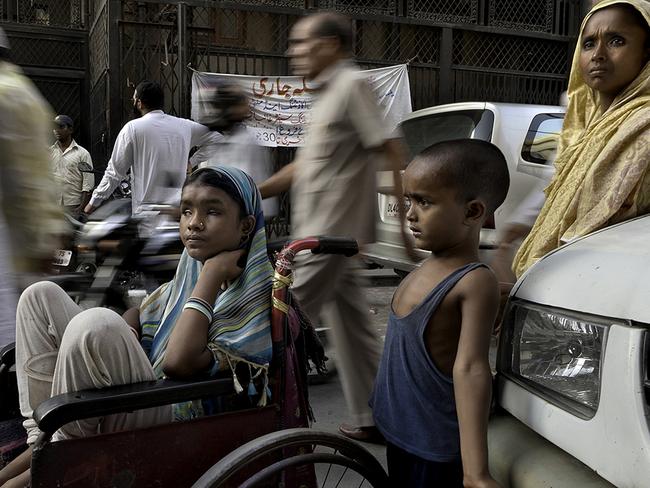 Blind Hunupa Begum, 13, begs for her family in New Delhi, in a wheelchair donated by a passerby. Centre, her brother Hajimudin Sheikh, and, right, her mother Manora. Picture: Renee Byer