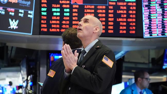 Traders work on the floor at the opening bell of the Dow Industrial Average at the New York Stock Exchange on March 18, 2020 in New York. - Wall Street stocks resumed their downward slide early Wednesday as the economic toll mounts from the rapid near-shutdown of key industrial and services sectors.About 15 minutes into trading, the Dow Jones Industrial Average stood at 20,040.66, down around 1,200 points or 5.6 percent. (Photo by Bryan R. Smith / AFP)