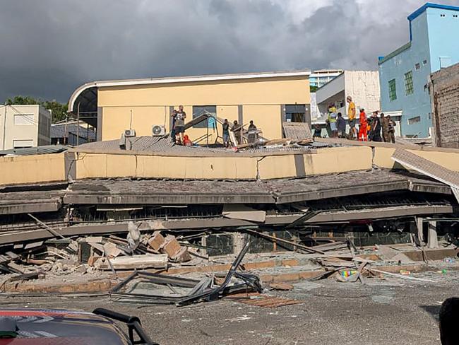 Rescue workers are seen at the site of a collapsed building after a powerful earthquake struck Port Vila, the capital city of Vanuatu, on December 17, 2024. A powerful earthquake hit the Pacific island of Vanuatu on December 17, smashing buildings in the capital Port Vila including one housing the US and other embassies, with a witness telling AFP of bodies seen in the city. (Photo by AFP)