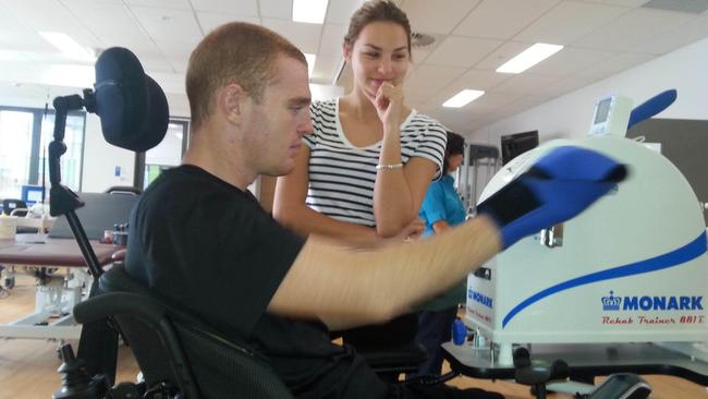 Alex working on the hand cycle while Teigan watches on.