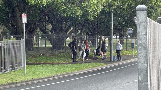 Commuters line-up at a bus stop in Southport on Monday morning with tram services out of action.