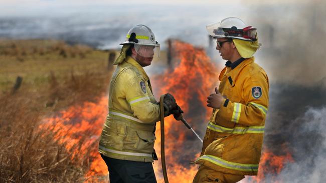 Fireys consult as they keep flames at bay. Picture: Gary Ramage