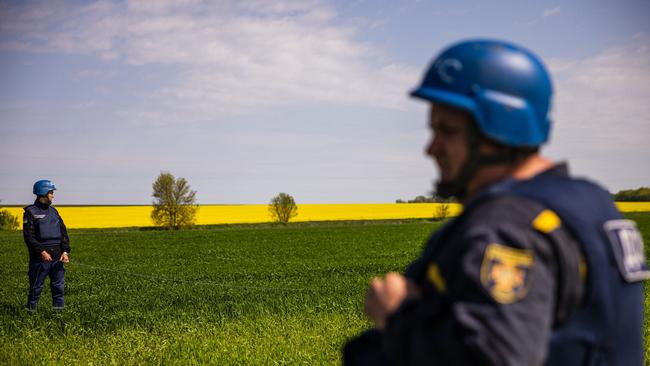 Members of a demining team of the State Emergency Service of Ukraine prepare to destroy an unexploded missile remaining near the village of Hryhorivka. It's planting season in Ukraine and in addition to a spiking need for fuel and fertiliser, demining teams are flooded with calls to destroy the unexploded missiles or mines in fields, which in some places have wounded or killed farmers.