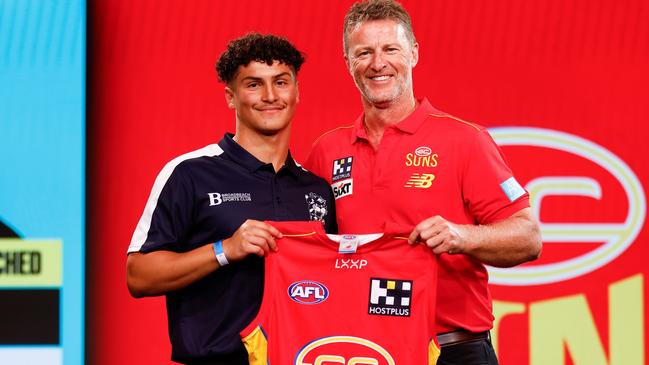 MELBOURNE, AUSTRALIA - NOVEMBER 20: Jake Rogers is seen with Damien Hardwick, Senior Coach of the Suns after being selected at number 14 during the 2023 AFL Draft at Marvel Stadium on November 20, 2023 in Melbourne, Australia. (Photo by Michael Willson/AFL Photos via Getty Images)