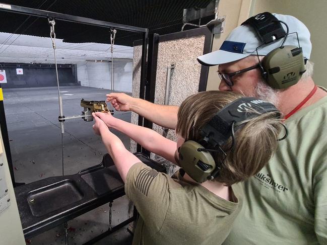 Tim Barron, co-director of a new public shooting gallery called the Gold Coast Shooting Centre, instructs a 12-year-old boy on the best way to fire a Desert Eagle .44 Magnum pistol, which was locked into a custom designed tethering system. Picture: Supplied