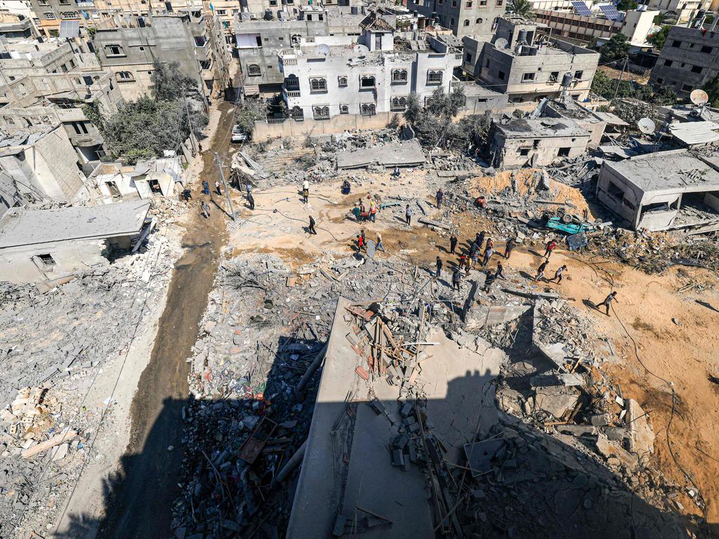 Palestinians gather to search for survivors in rubble of a collapsed building following an Israeli strike, in Khan Yunis in the southern Gaza Strip on October 14. Picture: AFP