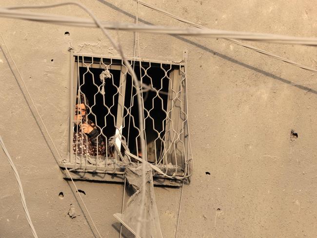 A woman stares from the window of a damaged building at the destruction caused by an Israeli strike in the Al-Maghazi refugee camp in Deir Balah in the central Gaza Strip. Picture: AFP