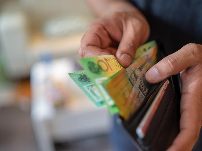 a male taking money out of a wallet, Australian cash generic spending