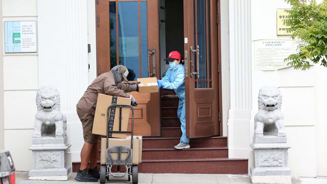 A UPS driver delivers packages to a worker at the Consulate General of China, where Juan Tang, a researcher at the University of California, took refuge before her arrest.