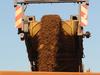 An earth mover receives iron ore from a surface miner in the mine pit at Fortescue Metals Group Ltd.'s Cloudbreak operation in the Pilbara region of Western Australia, on Monday, July 25, 2011. Fortescue Metals Group, Australia's third-biggest producer of iron ore, will release their full-year earnings on August 19. Photographer: Carla Gottgens/Bloomberg