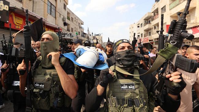 Palestinian militants carry the body of 19-year-old Ahmad Awawda who was killed in clashes with Israeli troops in the occupied West Bank region of Nablus the previous day, during his funeral in Jenin on October 8, 2023. Picture: Zain Jaafar/AFP