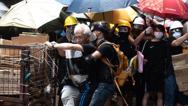 Pro-democracy lawmaker Leung Yiu-chung is held back by protesters. Picture: AFP