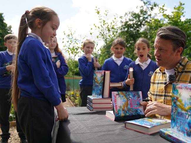 Jamie Oliver signs copies of his new book during a visit to Great Bradfords Junior School, in Braintree, Essex. Picture: Getty