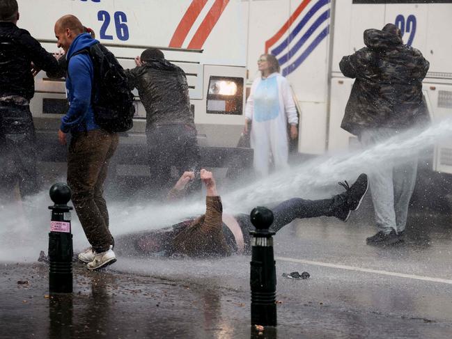 A protester is hit by a water cannon during clashes with riot police in Brussels. Picture: AFP