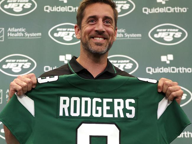 FLORHAM PARK, NEW JERSEY - APRIL 26: New York Jets quarterback Aaron Rodgers poses with a jersey during an introductory press conference at Atlantic Health Jets Training Center on April 26, 2023 in Florham Park, New Jersey. (Photo by Elsa/Getty Images)