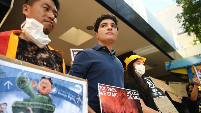 The University of Queensland senate will review the suspension of student and activist Drew Pavlou (centre).