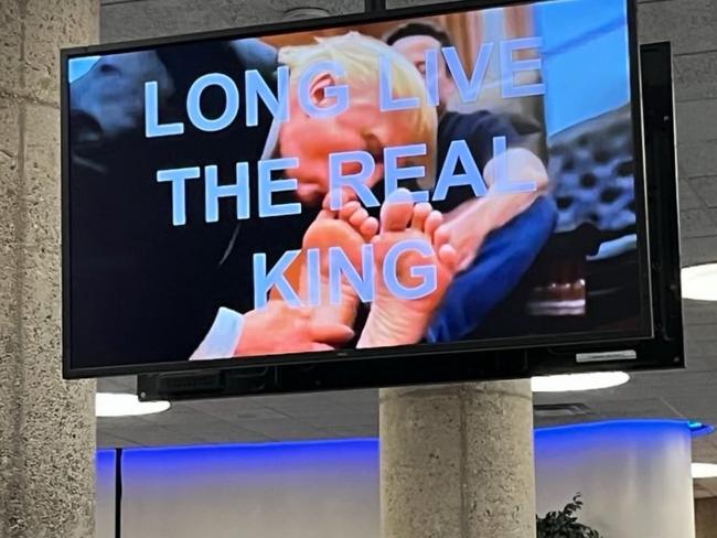 AI video of Trump kissing Musk’s feet plays on screens. Picture: X@rachsieg