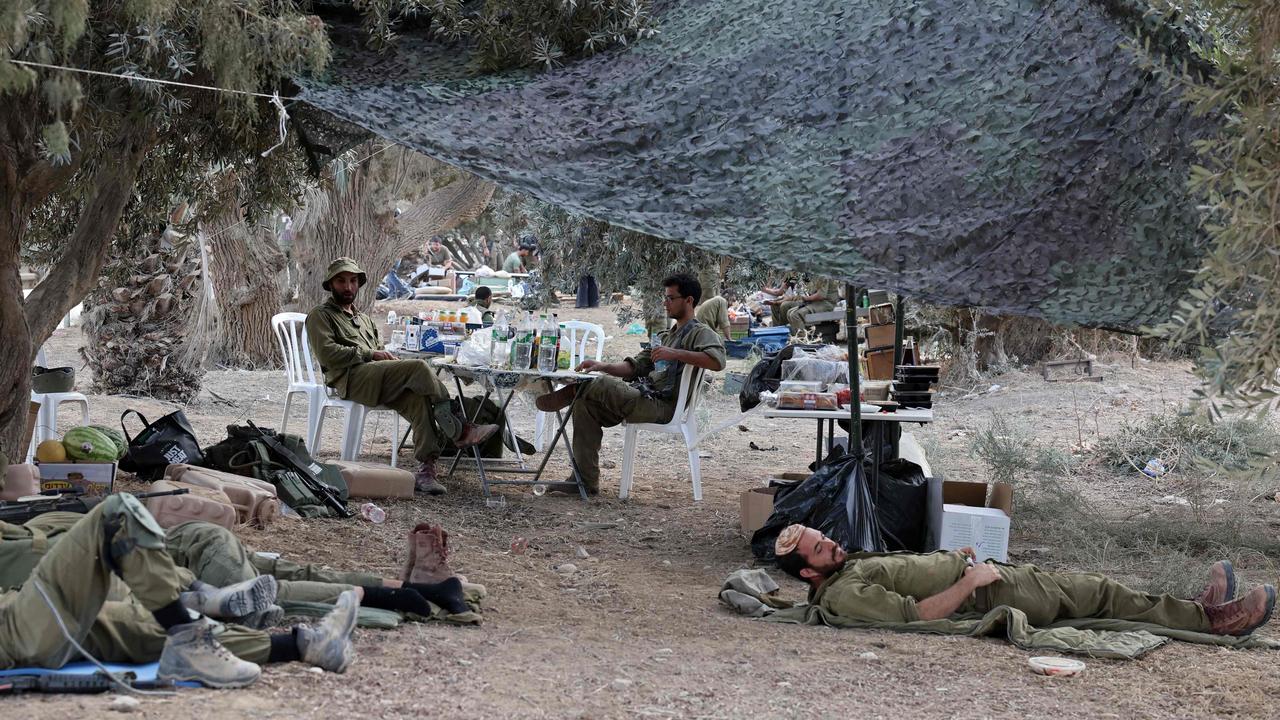 Israeli soldiers near the kibbutz where 270 revellers were gunned down or burnt in their cars at the Supernova music festival. Picture: AFP