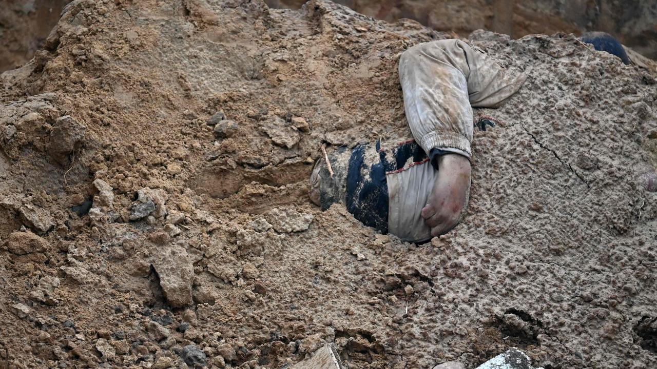 A body's hands are seen in a mass grave in Bucha, near Kyiv on April 9, 2022. Picture: Sergei Supinsky/AFP