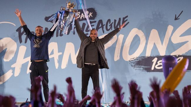 Manchester City captain Vincent Kompany, left, and manager Pep Guardiola show the Premier League trophy to supporters outside the Etihad Stadium in Manchester. Picture: AFP